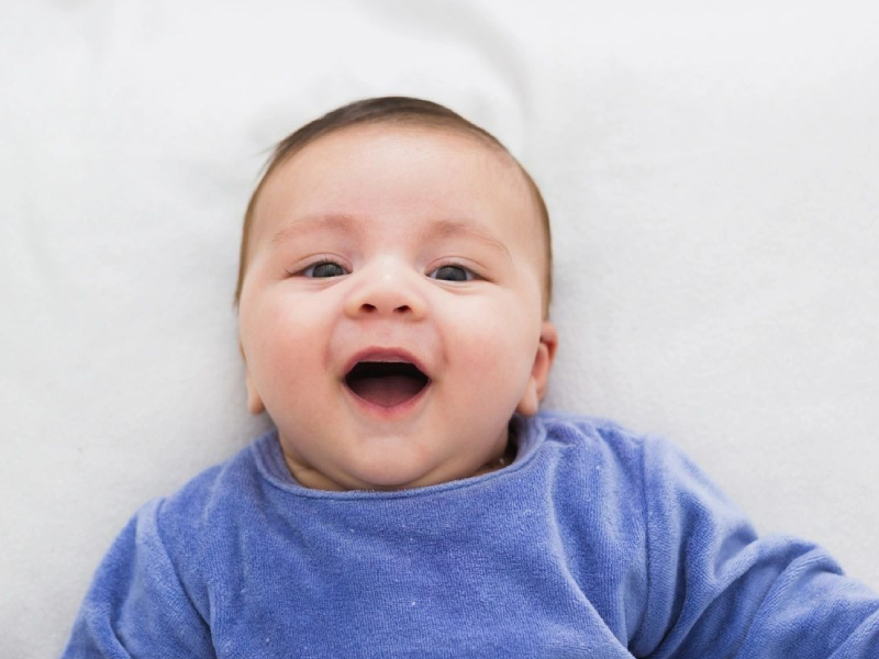 Close up of smiling baby lying in his crib