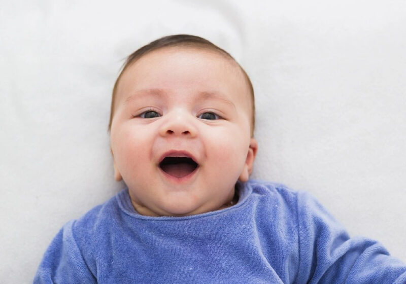 Close up of smiling baby lying in his crib